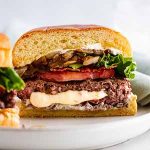 a pepper jack juicy lucy cut in half on a plate.