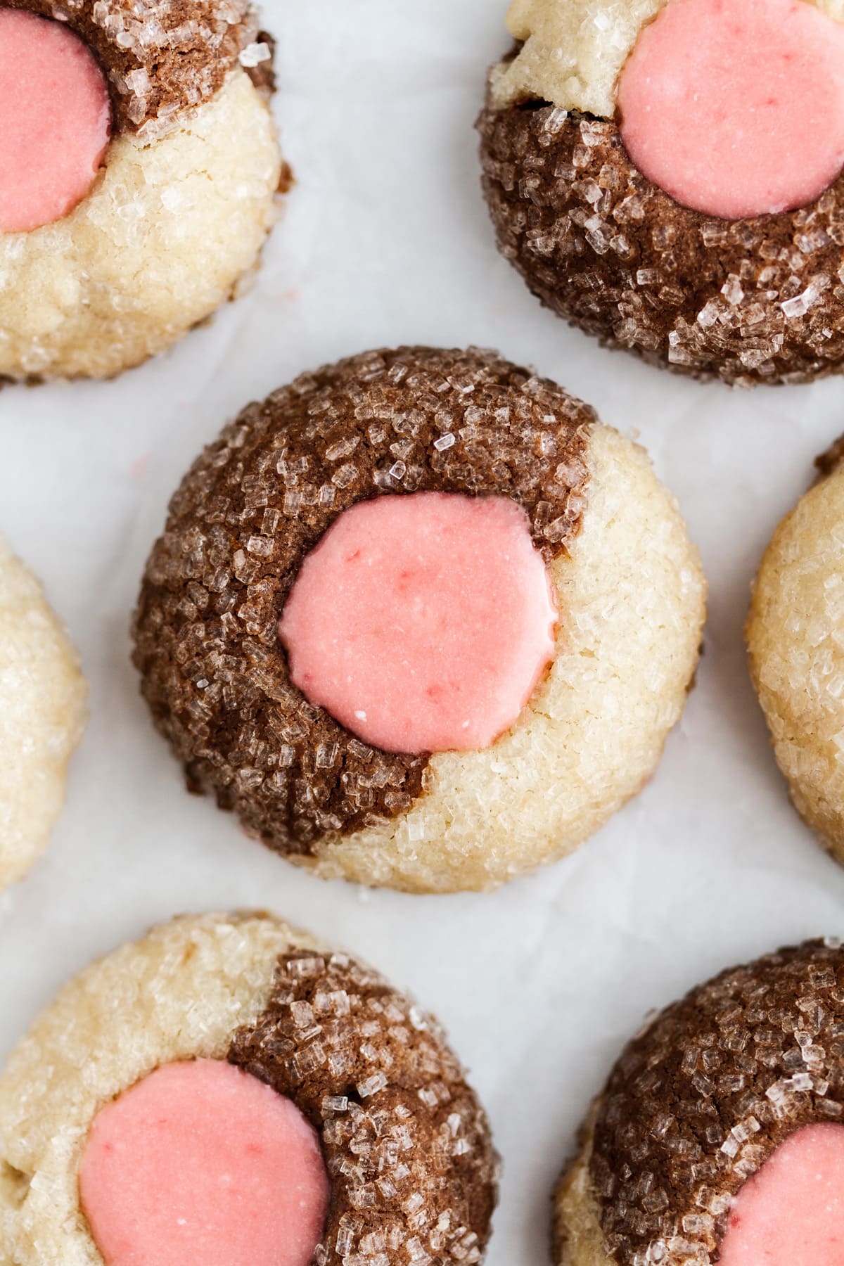Neapolitan thumbprint cookies on a sheet of parchment paper