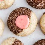 Neapolitan thumbprint cookies on parchment paper.