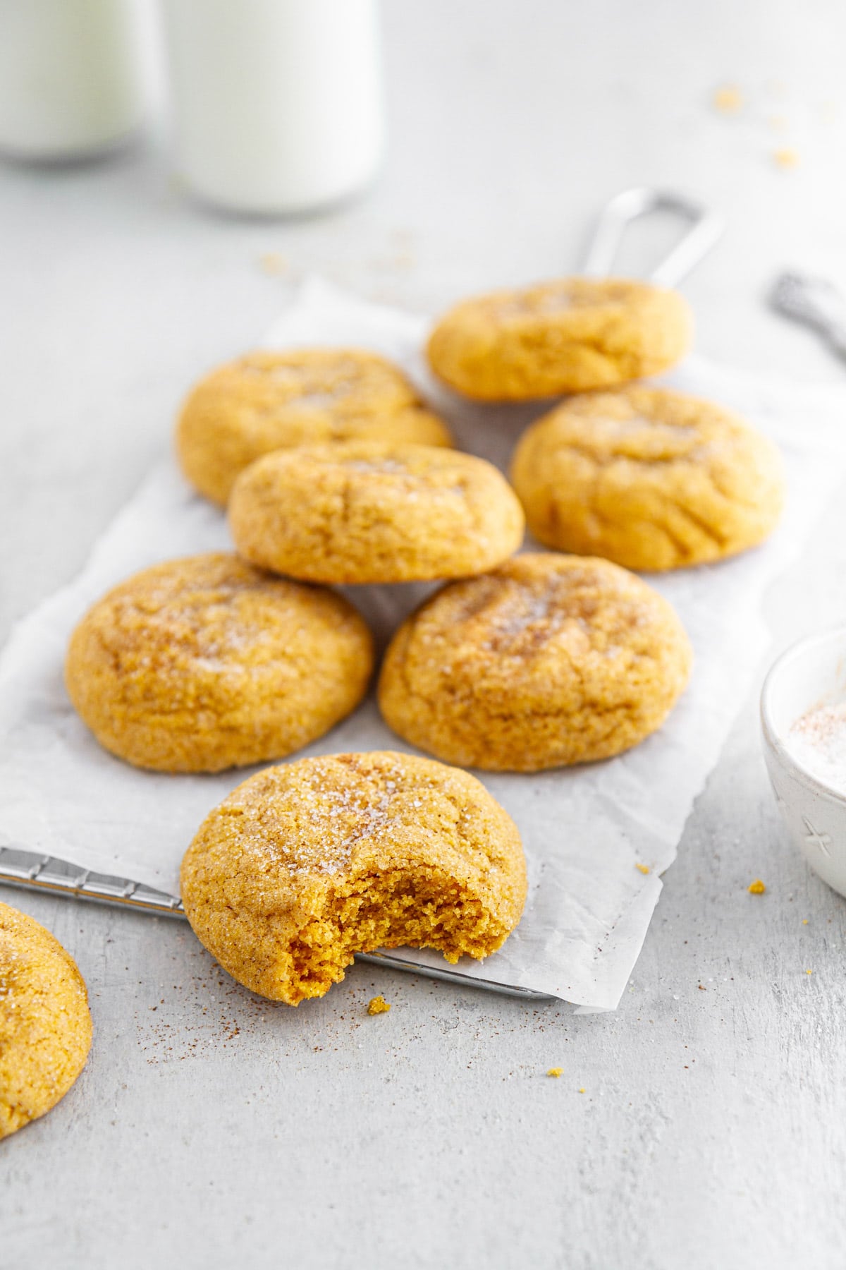 pumpkin snickerdoodles on a parchment paper-lined cooling rack