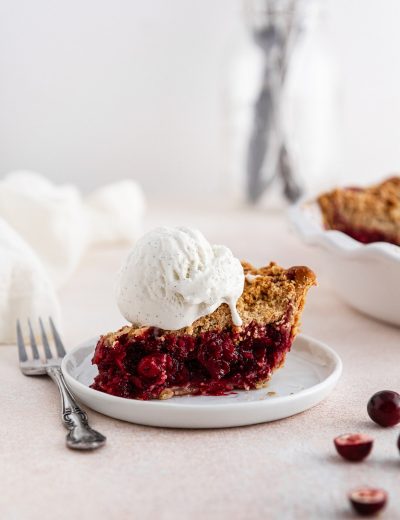 a slice of cranberry crumble pie with ice cream on top