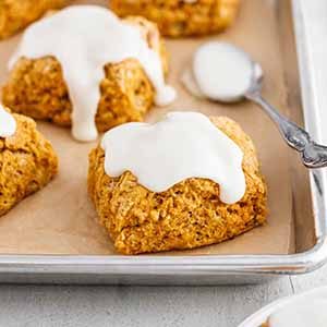 sweet potato biscuits with marshmallow icing on a baking sheet.