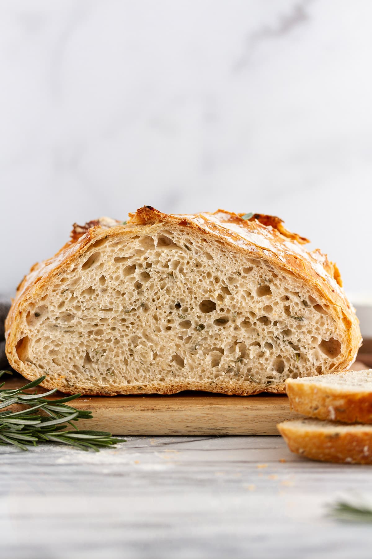 sliced rosemary-garlic no-knead bread on a cutting board