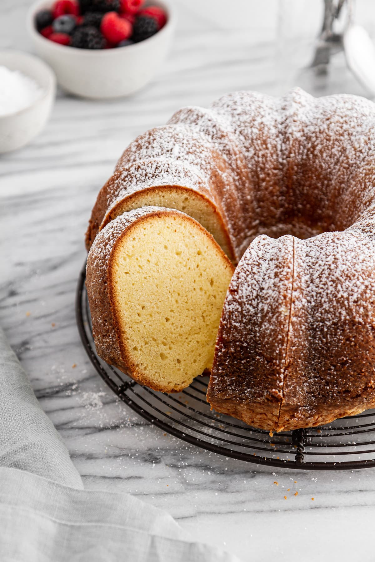 a sliced sour cream pound cake on a cooling rack