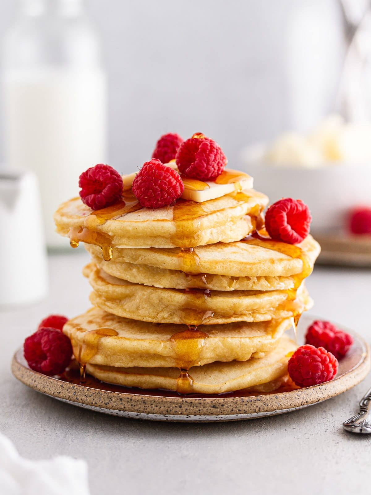sourdough pancakes on a plate with syrup dripping.