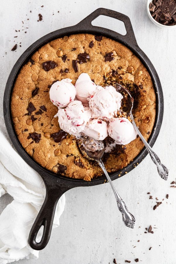 ice cream and spoons in a peanut butter chocolate skillet cookie