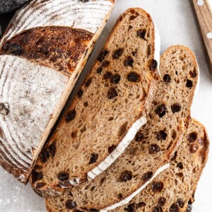 sliced cinnamon raisin sourdough loaf on white background.