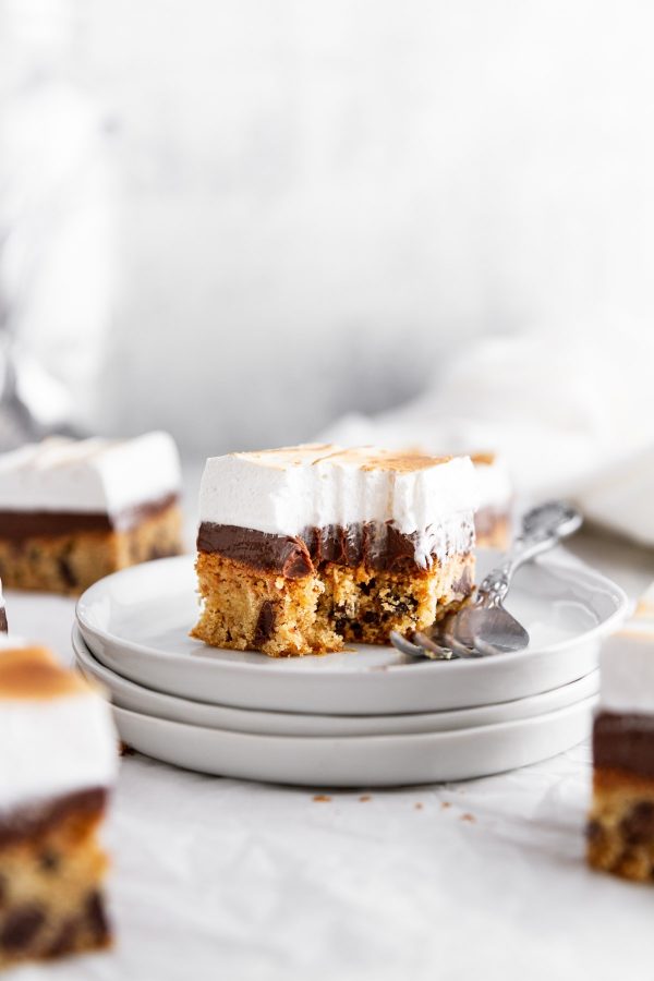 a s'more blondie on a stack of plates with a forkful taken out of it