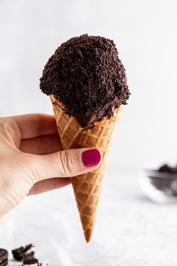 hand holding one cookies and cream ice cream drumstick