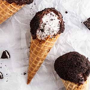 cookies and cream ice cream drumsticks on a surface.