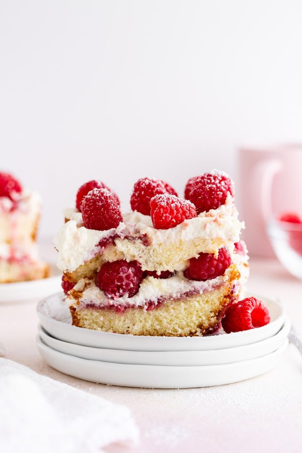 a piece of raspberry pound cake tiramisu on a stack of plates