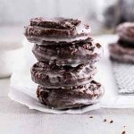 stacked chocolate old-fashioned donuts on parchment paper.
