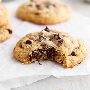 gluten free chocolate chip cookie with a bite taken out of it.
