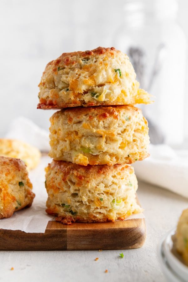 stack of cheddar-scallion biscuits on a cutting board