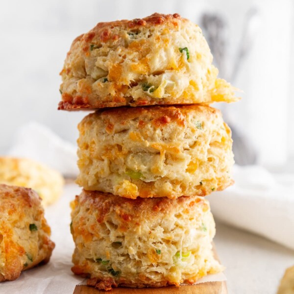 stack of cheddar-scallion biscuits on a cutting board.