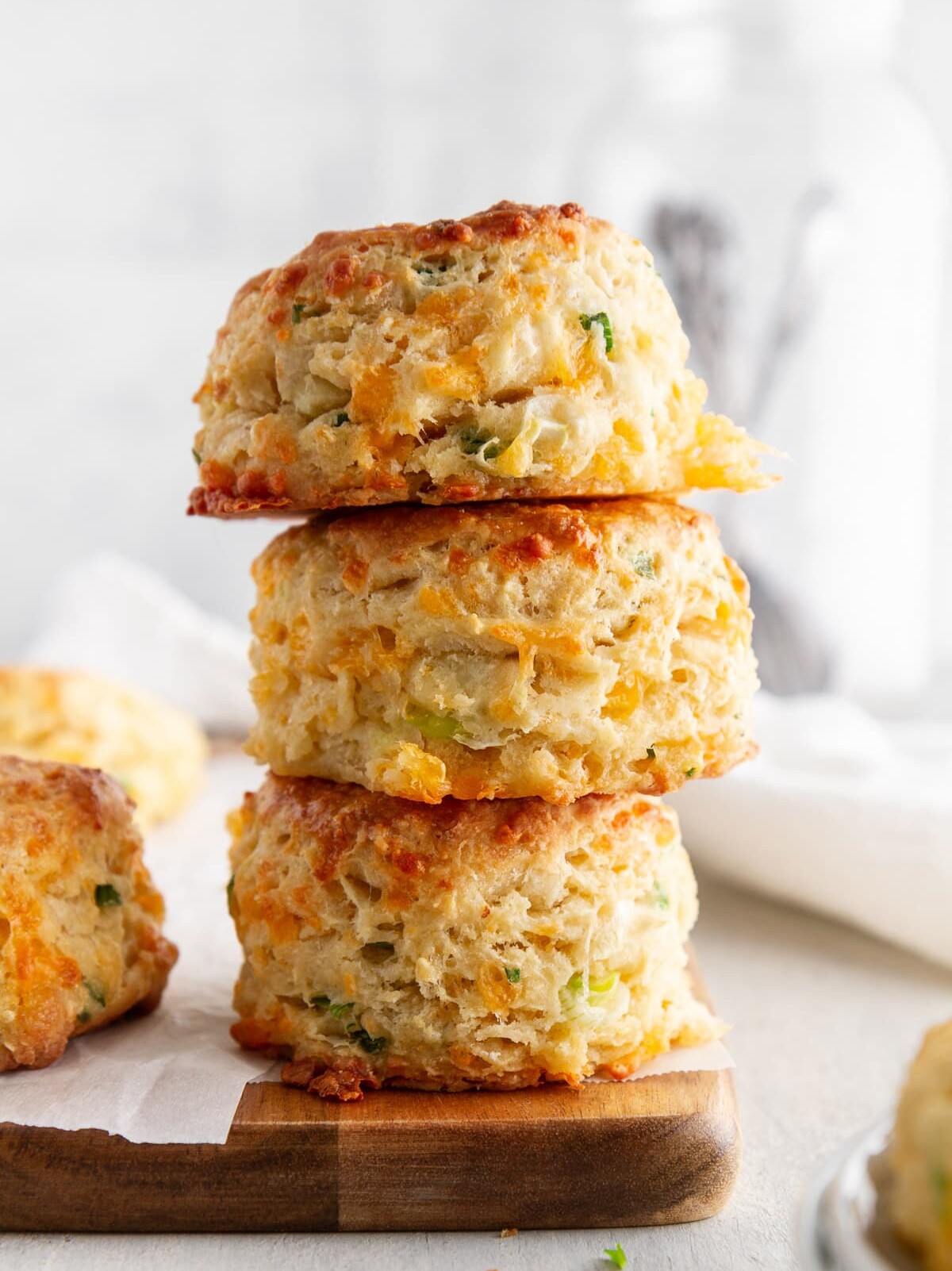 stack of cheddar-scallion biscuits on a cutting board.