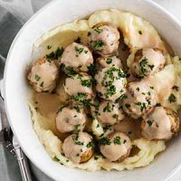 crockpot Swedish meatballs in a bowl with mashed potatoes