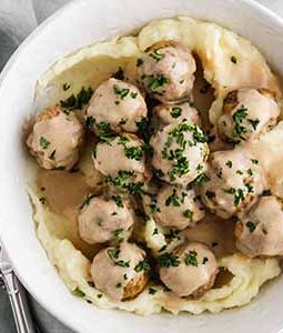 crockpot Swedish meatballs in a bowl with mashed potatoes