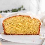 sliced iced clementine pound cake on parchment paper.