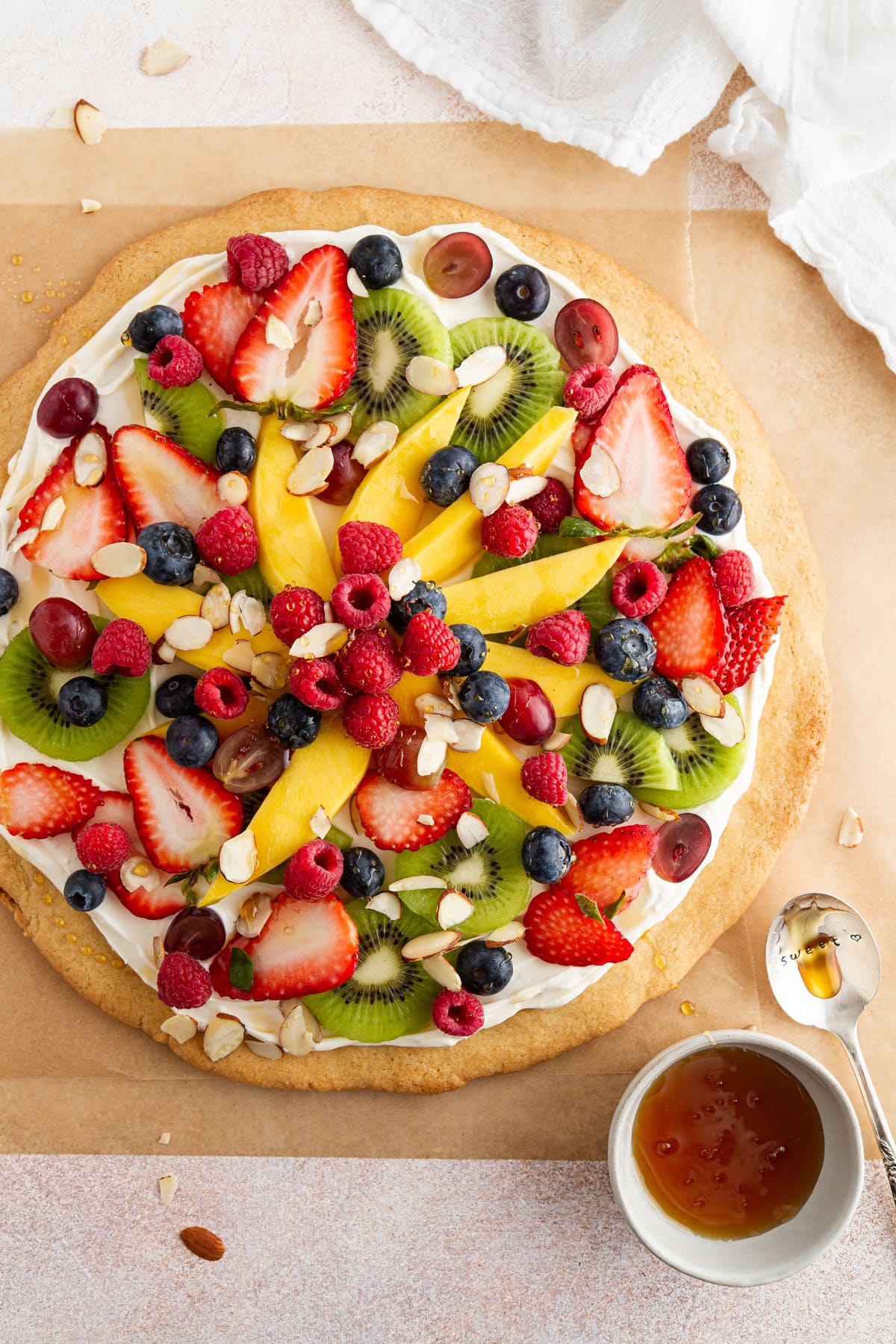 overhead shot of fruit pizza on parchment. paper