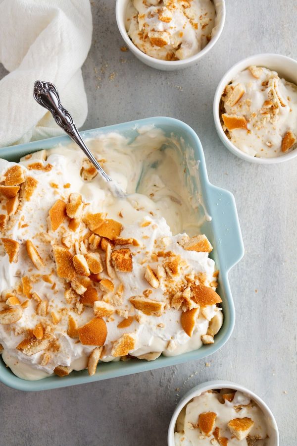 bowls of banana pudding around a baking dish with banana pudding spooned out