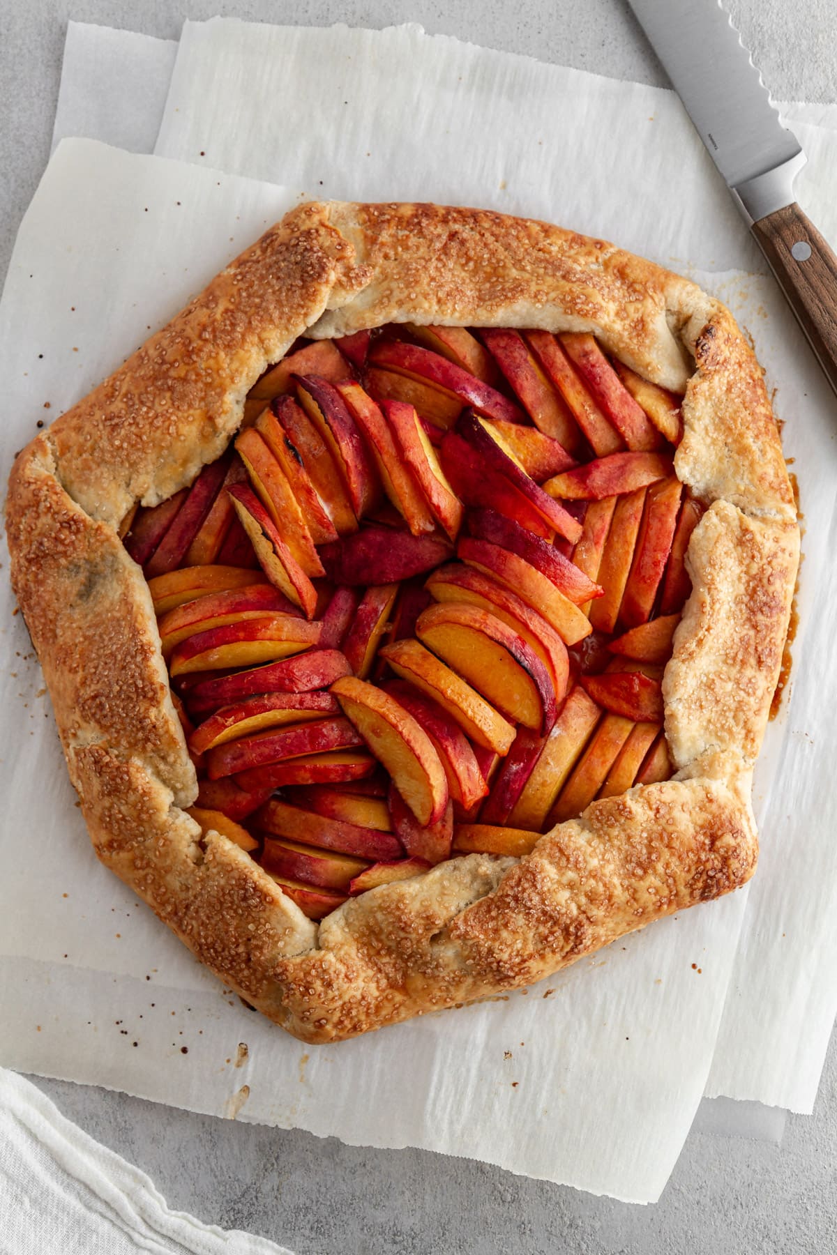overhead shot of peach galette on parchment paper