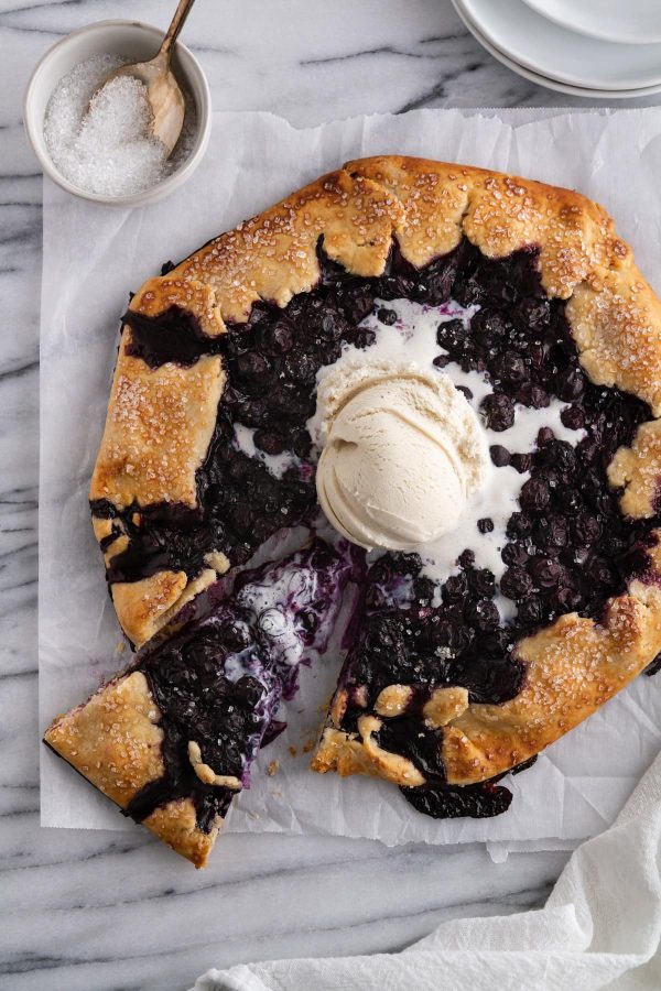 blueberry galette on a surface with a slice taken out of it