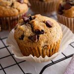 closeup of chocolate chip banana muffin on a cooling rack.