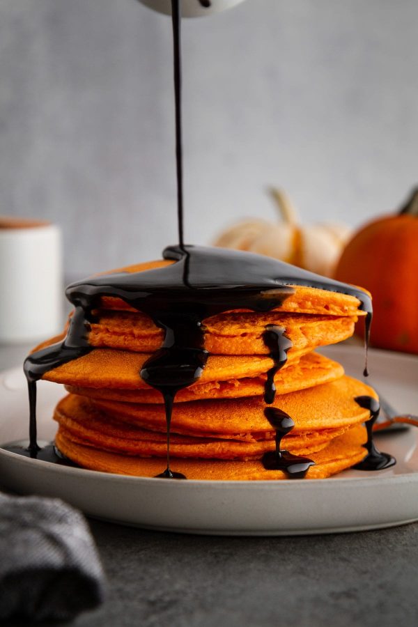 halloween pancakes on a plate with syrup poured on top