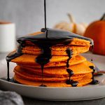 halloween pancakes on a plate with syrup poured on top.