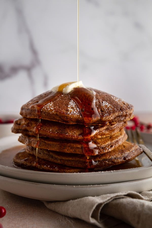 stack of pancakes on a plate with a drizzle of maple syrup on top