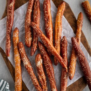 homemade hard pretzel rods stacked on a cutting board.