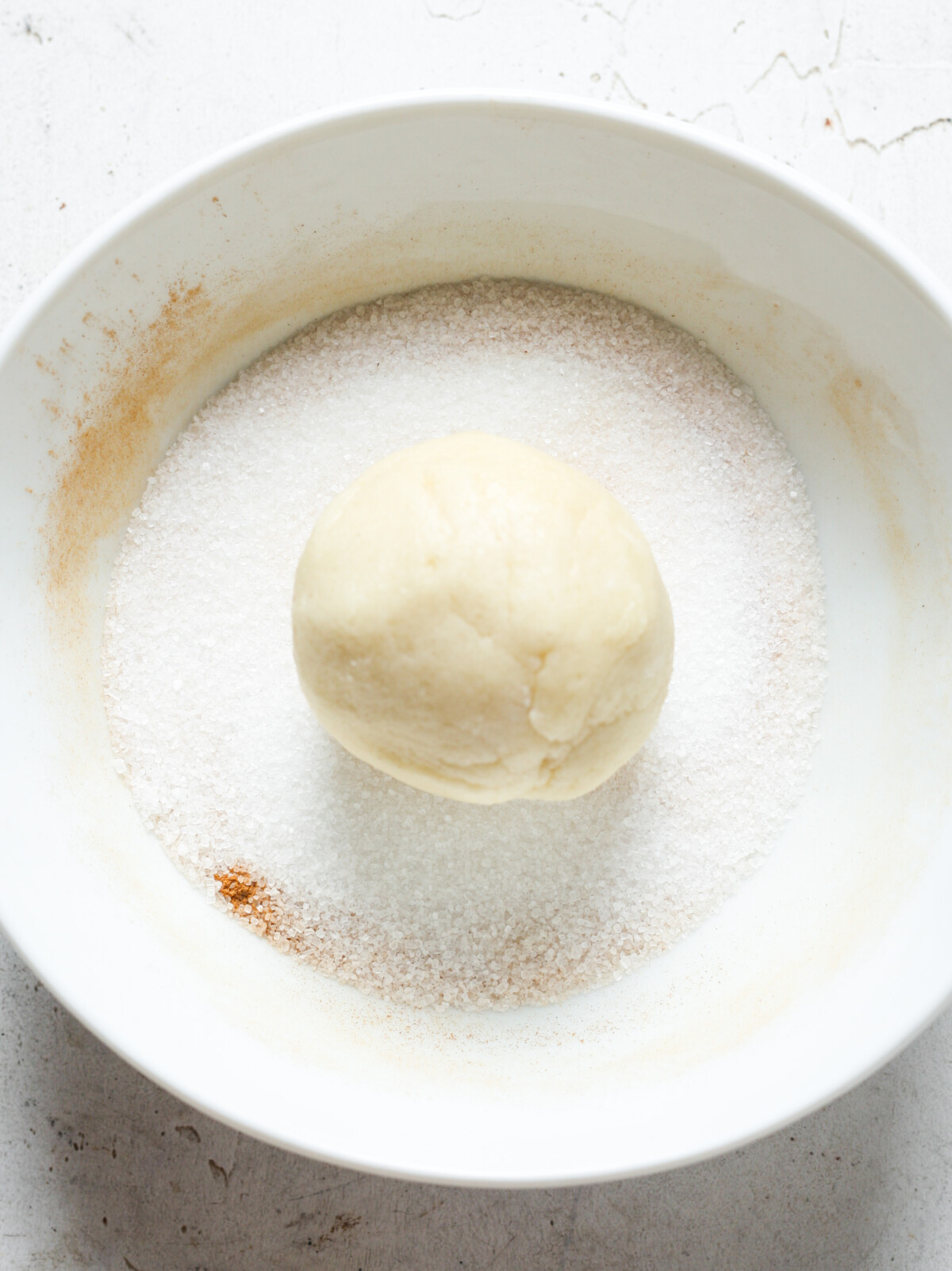 Ball of dough in cinnamon sugar.