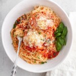 chicken parmesan in white bowl with sauce.