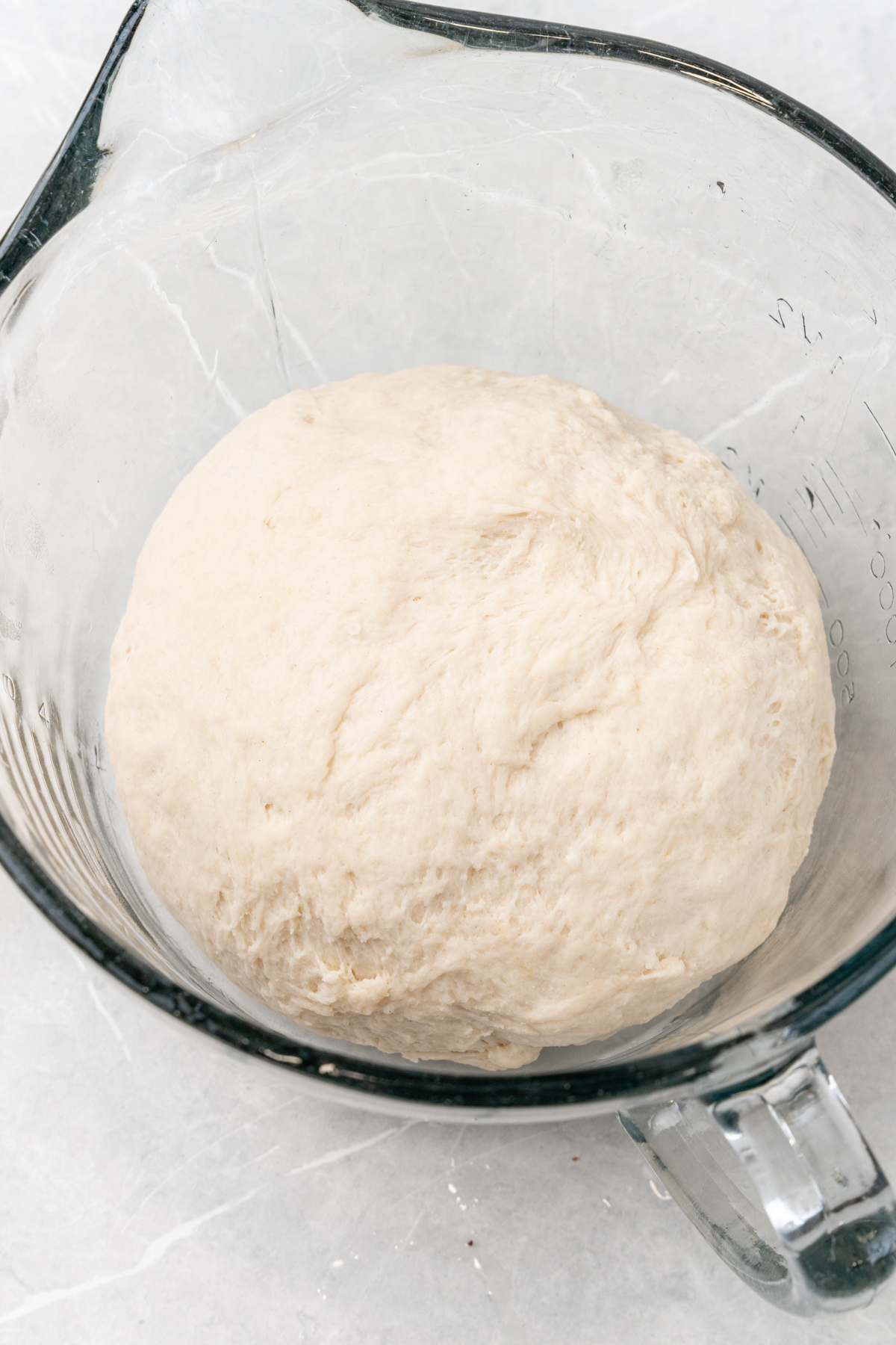 Ball of dough in glass bowl.