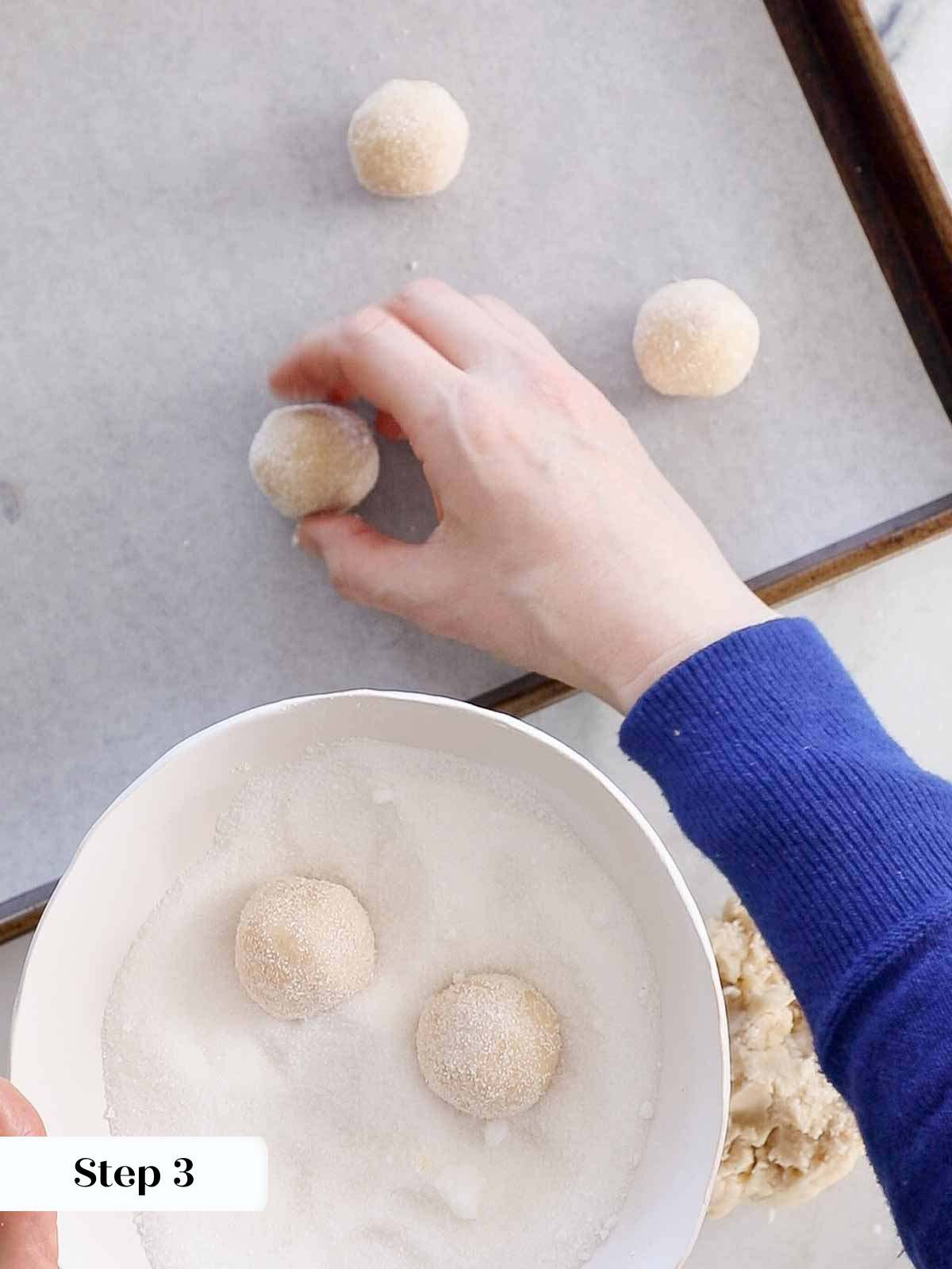 rolling cookie dough in sugar.