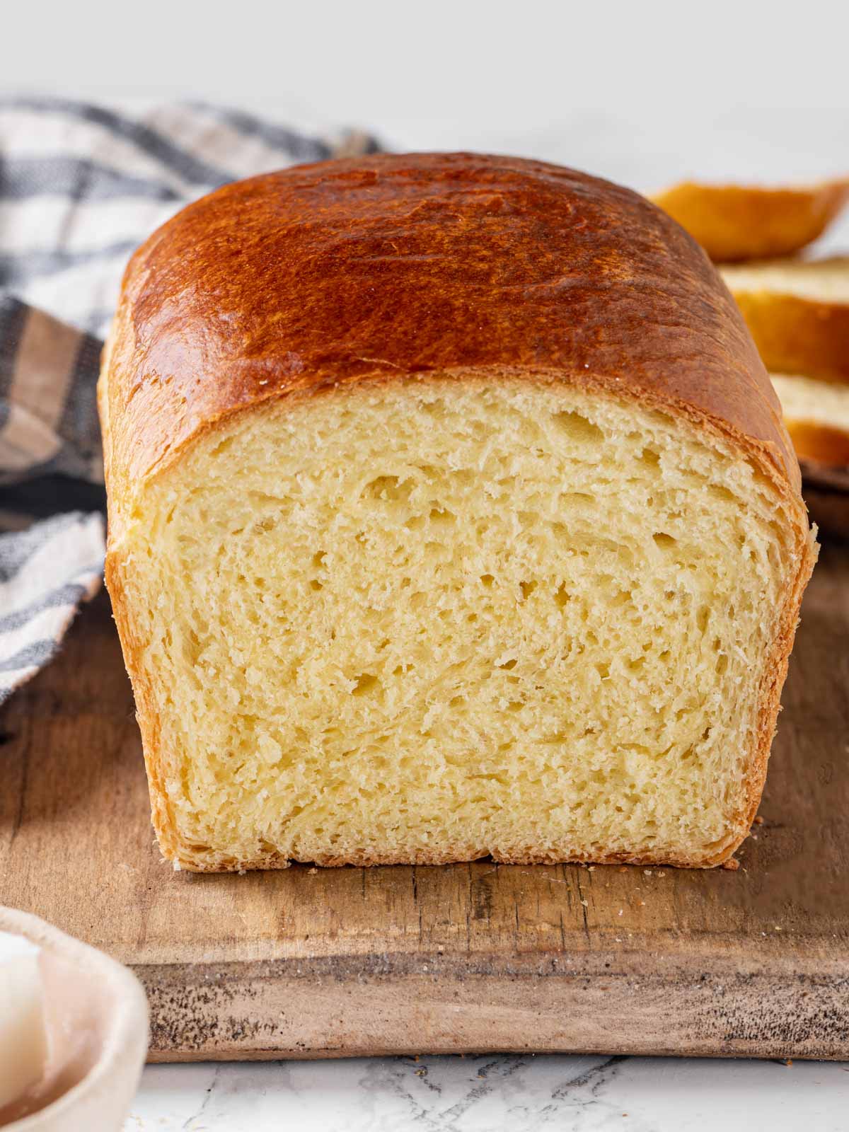 baked brioche sliced open to show interior crumb. 
