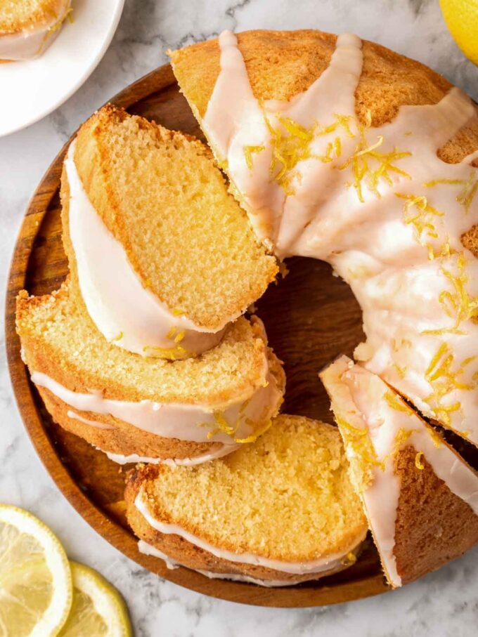 slices of lemon bundt cake layered around cake plate.