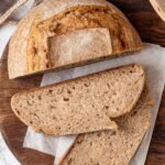 sliced whole wheat sourdough on cutting board.