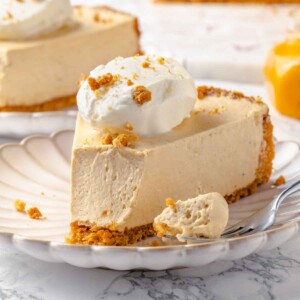 A slice of pumpkin no-bake cheesecake with a silver fork on the side.