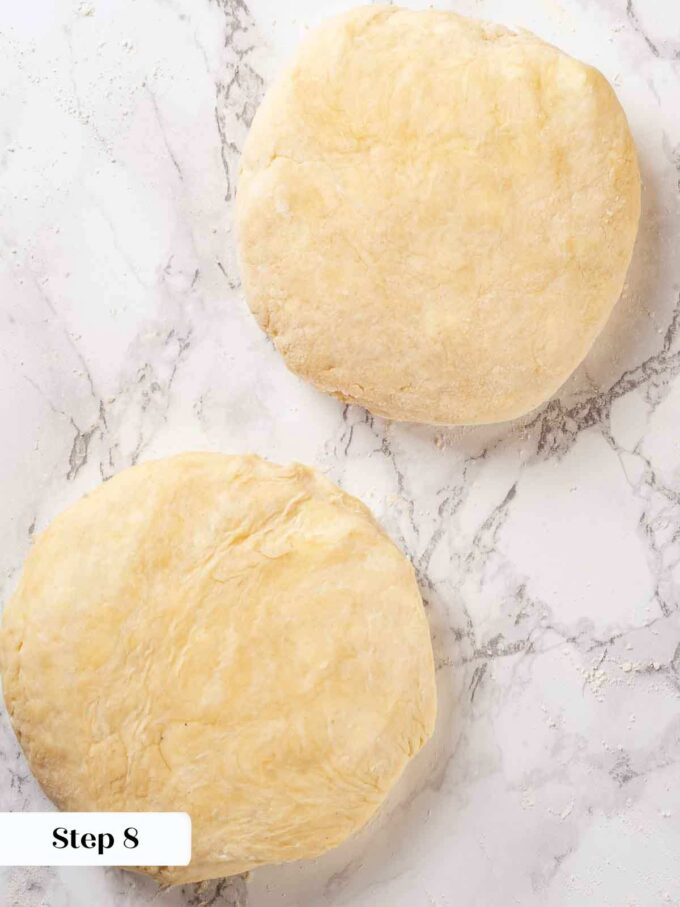 two disks of pie dough on marble.