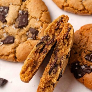 A cookie split in half revealing a gooey chocolate-studded interior.