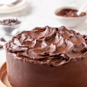 A cake decorated with chocolate fudge frosting, smoothed with a spatula for an even finish.