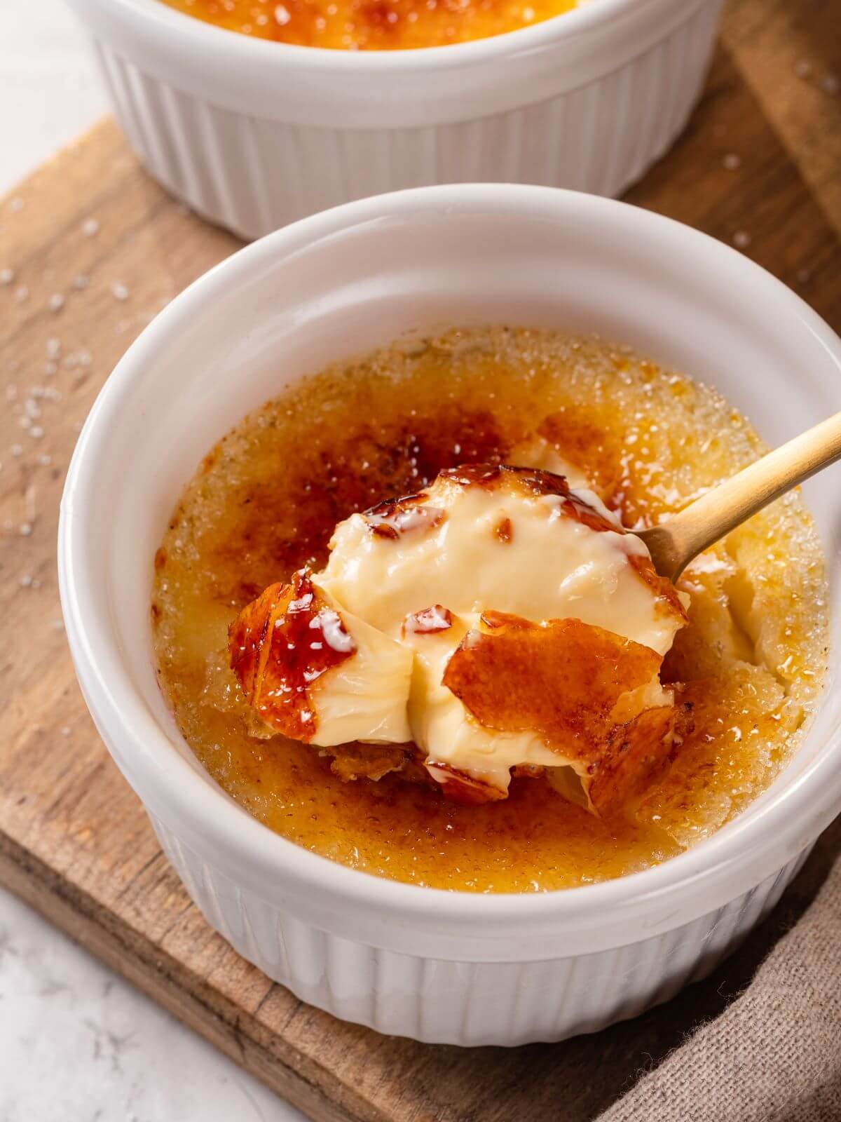 A spoonful of rich, creamy creme brulee custard showing its silky texture.