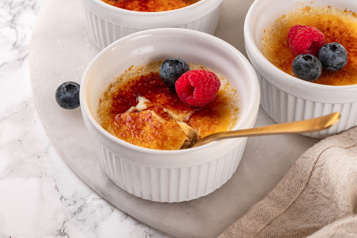 A freshly made creme brulee sitting on a marble countertop, ready to be enjoyed.