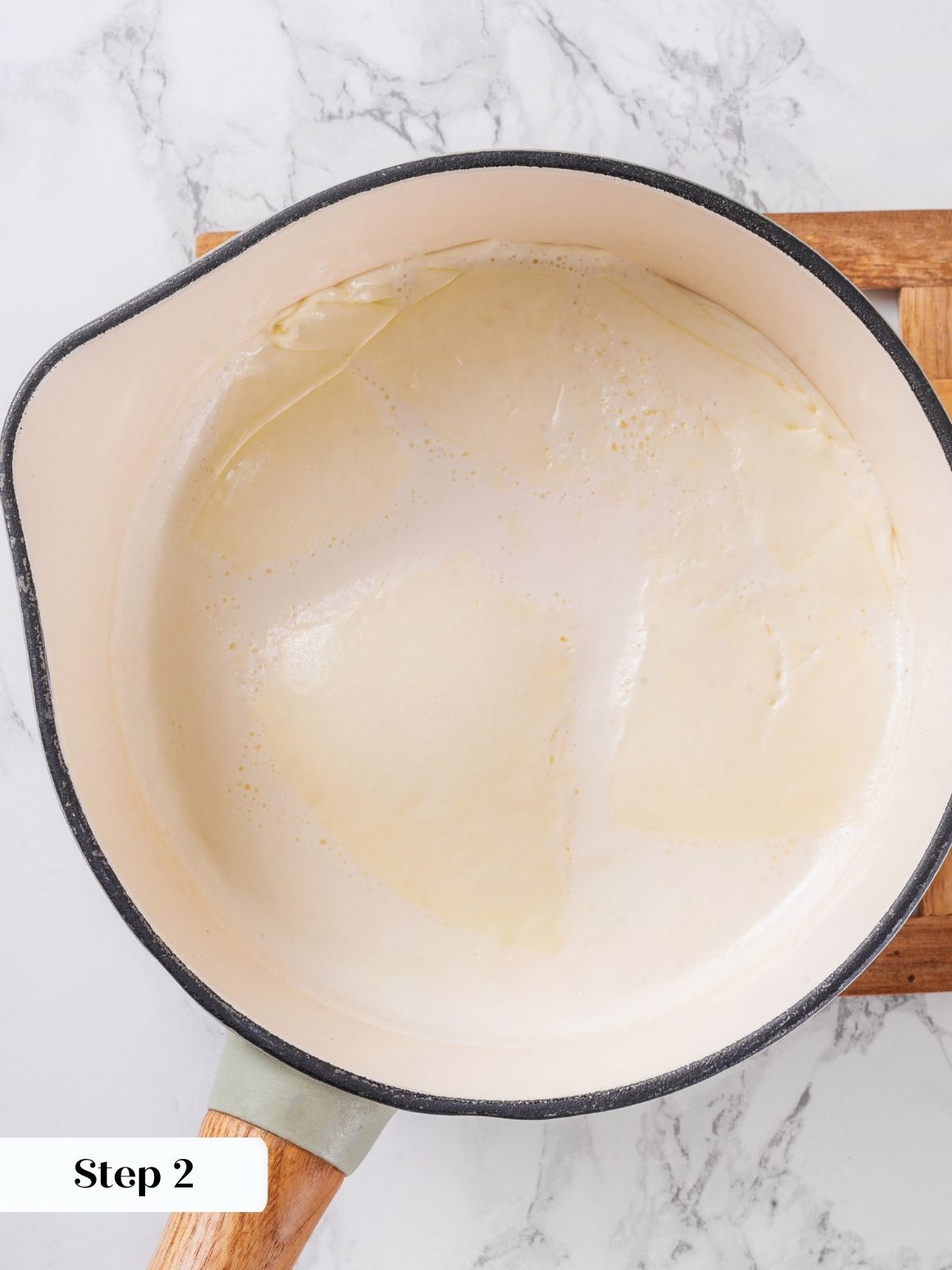 Heavy cream heating in a saucepot, ready to be combined with egg yolks for creme brulee.