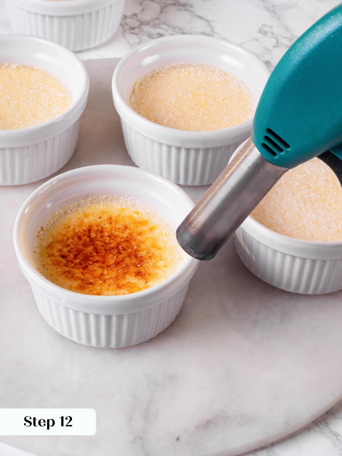 A kitchen torch caramelizing the sugar on top of a creme brulee for a crisp finish.