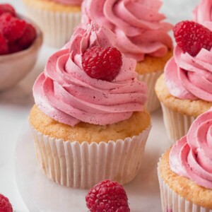 Raspberry cupcakes topped with vibrant pink frosting, beautifully swirled for a delightful presentation.