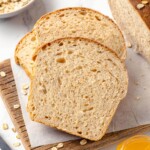 Multiple slices of oatmeal bread fanned out on a board.