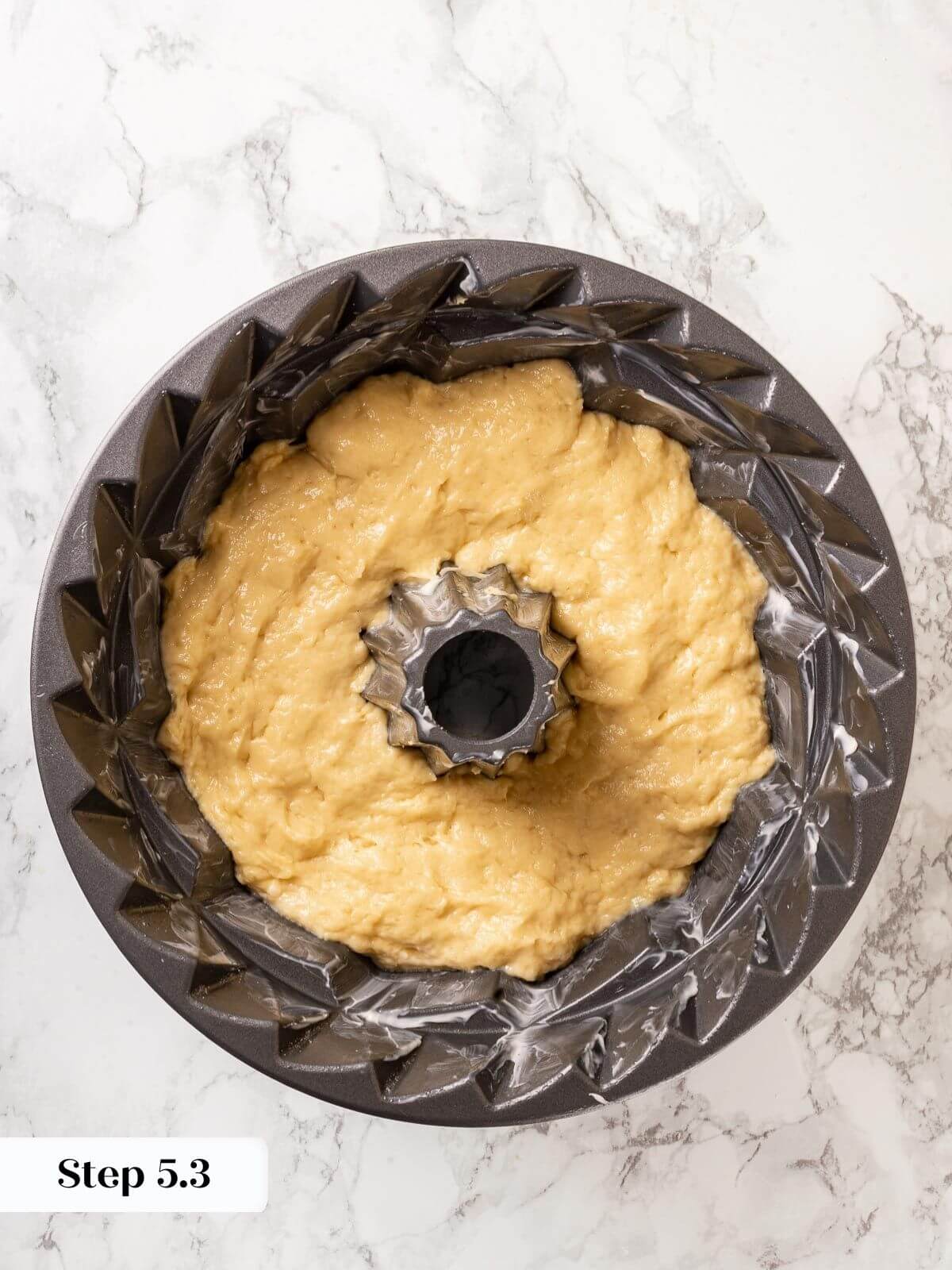 Unbaked Sally Lunn dough resting in a shaped mold.